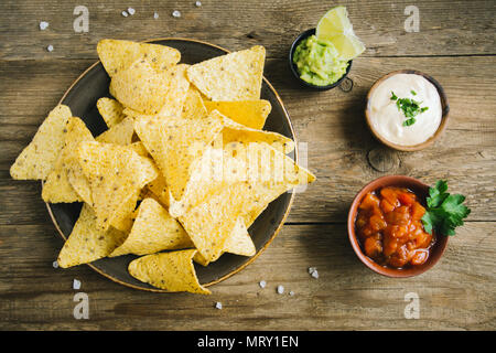 Nachos chips et diverses sauces dip, Close up. Maïs tortilla chips nachos avec de la salsa, de fromage fondu et de guacamole mexicain, des collations. Banque D'Images