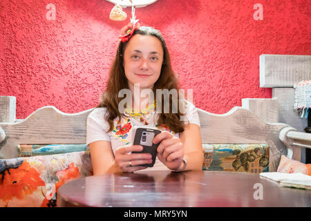 Woman touching sur smartphone à vous détendre dans le café le temps d'un café. Belle femme dans un café utilise un smartphone Banque D'Images