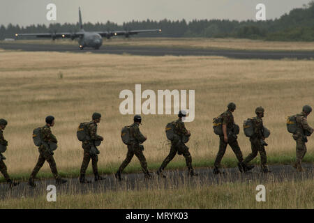 Plusieurs pays de l'OTAN de parachutistes à pied vers un U.S. Air Force C-130J Super Hercules à bord pendant la Semaine internationale Jump plus de Bitburg, en Allemagne, Juillet 11, 2017. Environ 500 militaires de plus de 13 pays partenaires ont participé à cette année de formation. (U.S. Photo de l'Armée de l'air par la Haute Airman Tryphena Mayhugh) Banque D'Images