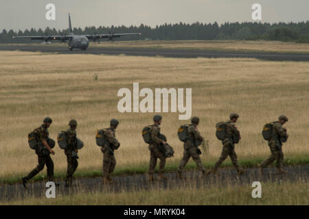 Plusieurs pays de l'OTAN de parachutistes à pied vers un U.S. Air Force C-130J Super Hercules à bord pendant la Semaine internationale Jump plus de Bitburg, en Allemagne, Juillet 11, 2017. Environ 500 militaires de plus de 13 pays partenaires ont participé à cette année de formation. (U.S. Photo de l'Armée de l'air par la Haute Airman Tryphena Mayhugh) Banque D'Images