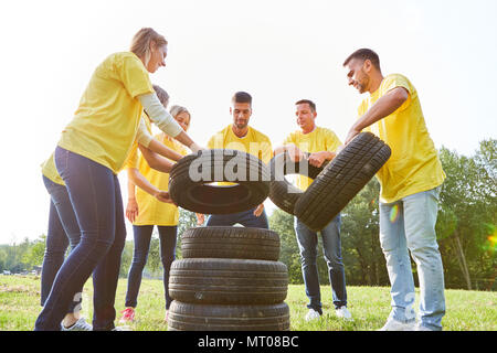 Groupe de jeunes piles pneus auto dans un projet d'équipe dans la nature Banque D'Images