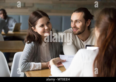 Heureux couple millénaire de signer un contrat hypothécaire planification à moi Banque D'Images