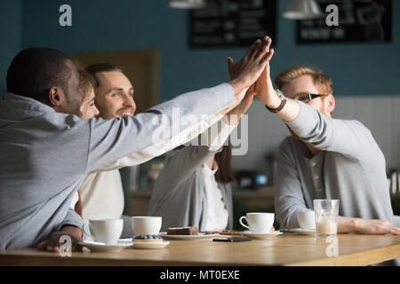 Heureux amis multiraciale cafe haut donnant cinq à répondre à ca Banque D'Images