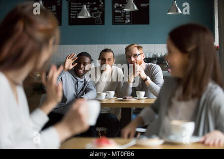 African smiling man waving hand filles accueil réunion de cafe Banque D'Images