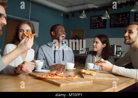Heureux multiraciale friends laughing millénaire toget eating pizza Banque D'Images