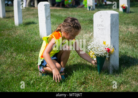 Bell Makenna jette des fleurs sur une tombe dans l'article 21 du Cimetière National d'Arlington, Arlington, Va., le 17 juillet 2017. Plus de 400 professionnels ont participé à paysage bénévole l'Association nationale des professionnels du paysage et de renouvellement annuel 21 souvenir à l'ANC. (U.S. Photo de l'armée par Elizabeth Fraser / Arlington National Cemetery / relâché) Banque D'Images