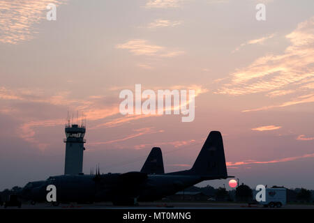 Le soleil se lève sur le C-130H Hercules sur la piste à la 179e Airlift Wing, Mansfield, Ohio, dans la matinée du 19 juillet 2017. La 179e Escadre de transport aérien est toujours pour mission d'être le premier choix pour répondre à la communauté, de l'État fédéral et les missions d'une équipe de confiance d'aviateurs hautement qualifiés. (U.S. Photo de la Garde nationale aérienne d'un membre de la 1re classe Megan Shepherd/libérés) Banque D'Images