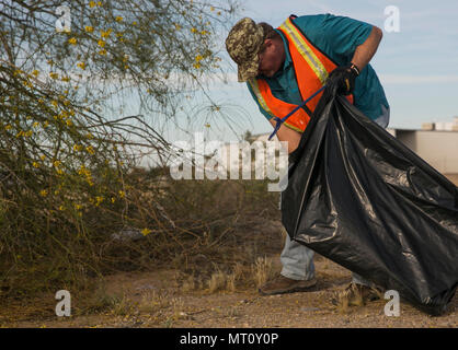 Jerry McCluskey, volontaire de la Marine Corps Air Station Yuma Ministère de l'environnement, veille à ce que la corbeille à côté de la rue Palo Verde est nettoyée, le lundi 17 avril, 2017 à MCAS Yuma, Arizona MCAS Yuma adopté cette rue il y a plus de 17 ans, et a aidé à garder propre chaque année. Banque D'Images