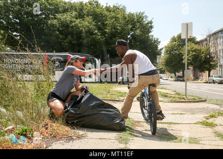 Un résident local merci Sarah Johnson pour son travail acharné et de compensation corbeille brosse dans un terrain vague à Baltimore, Maryland, dans le cadre de la séance inaugurale de l'Académie a gagné des batailles, le 15 juillet 2017. L'Académie a gagné des batailles est une partie de la Marine Corps' Semper Fidelis All-American" Programme, qui reconnaît les jeunes hommes et femmes qui excellent dans l'athlétisme, mais ont également montré eux-mêmes d'être des leaders dans leur classe et dans leur ville. Quatre-vingt-dix-sept étudiants-athlètes de l'école secondaire est allé(e) à l'académie, qui a porté sur le développement de leur confiance en soi, la discipline, le travail d'équipe, et au perfectionnement de l'esprit combatif que embodie Banque D'Images