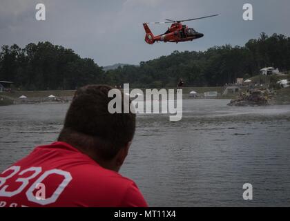 Andrew Reed, une troupe de scouts de la vie 1330 à New Jersey observe son père, le lieutenant de la Garde côtière canadienne le Cmdr. Jamie Reed, un pilote d'Air Station Atlantic City et eagle scout, piloter un hélicoptère MH-65 Dolphin au cours d'une démonstration de survie en eau. Plus de 30 000 scouts, chefs de troupes, les bénévoles et les membres du personnel professionnel, ainsi que plus de 15 000 visiteurs sont attendus à la 2017 Jamboree National. Environ 1 400 militaires du ministère de la Défense nationale et la garde côtière des États-Unis sont de fournir un soutien logistique pour l'événement. (U.S. Photo de l'armée par le Sgt. Jazmin Jenkins/22e Mob Banque D'Images