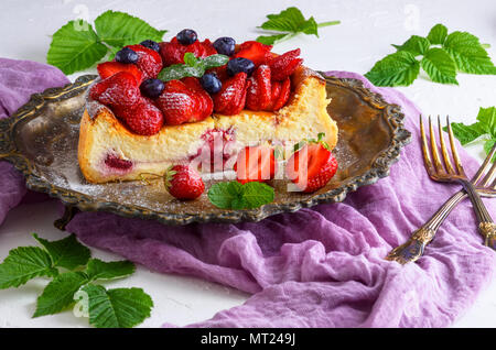 Cheesecake fait de fromage blanc et de fraises fraîches sur une assiette, décoré avec des fraises et des bleuets Banque D'Images