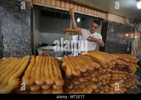 Alger. 27 mai, 2018. Un homme fait Zelabia, un Algérien traditionnel crêpe, à un dessert shop à Alger, Algérie, le 27 mai 2018. Zelabia est un aliment populaire en Algérie pendant le mois sacré du Ramadan. Source : Xinhua/Alamy Live News Banque D'Images