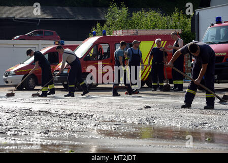 28 mai 2018, l'Allemagne, l'Herrstein : Les membres de la service de pompiers volontaires sont occupés à des travaux de nettoyage après les inondations de Herrstein (Kreis Birkenfeld). Photo : Harald Tittel/dpa Banque D'Images