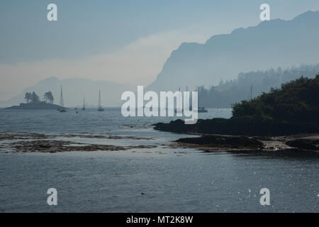 Discussion Les incendies dans l'ouest des Highlands d'Écosse provoquant un épais brouillard de fumée sur le port de Plockton dans la matinée. Banque D'Images