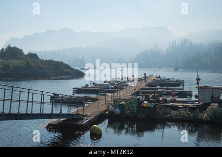 Discussion Les incendies dans l'ouest des Highlands d'Écosse provoquant un épais brouillard de fumée sur le port de Plockton dans la matinée. Banque D'Images