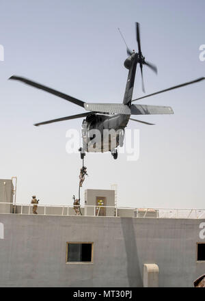 Abu Dhabi, EAU-membres du Centre de commandement des opérations spéciales (SOCCENT) sauter d'un hélicoptère UH-60 au cours d'une démonstration de formation à l'appui de la conférence des commandants des composants de l'USCENTCOM 21 juillet 2017. L'événement s'est tenu à souligner la Force de fonctionnement spécial conjoint de formation spécifiques et les compétences et les capacités qu'elles apportent à l'USCENTCOM zone de responsabilité. (Département de la Défense photo par U.S. Air Force Tech Sgt. Dana Flamer) Banque D'Images