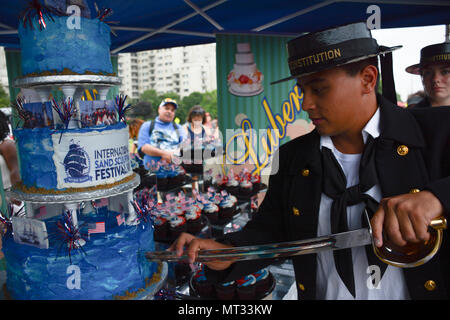 REVERE, Massachusetts (22 juillet 2017) Maître de Manœuvre 3 classe Austin Enriquez, affectés à l'USS Constitution, coupe un gâteau au cours de la 14e Festival International de sculpture sur sable à Revere Beach. Cette année, le festival de sculpture de sable à l'honneur du 220e anniversaire de l'USS Constitution passe cette année ainsi que sa ré-entrée dans l'eau le 23 juillet. (U.S. Photo par marine Spécialiste de la communication de masse Seaman Casey Azouz/libérés) Banque D'Images