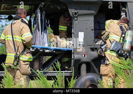 Les pompiers de Fort Bragg l'incendie et d'urgence évacuer une victime simulée d'un UH-60 Blackhawk hélicoptère pendant un scénario de formation d'urgence à Fort Bragg, Caroline du Nord, 25 juillet 2017. Les premiers intervenants en provenance de plusieurs domaines, l'ensemble de l'installation a réagi à l'incident en temps réel à mesure que le scénario d'une escalade. (U.S. Photo de l'armée par le Sgt. Paige Behringer) Banque D'Images