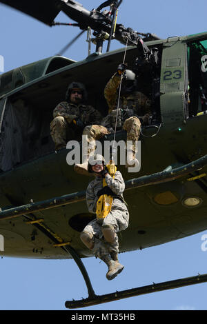 U.S. Air Force d'un membre de la 1re classe Ashlee Wiebe, du 119e Groupe médical, est hissé en haut et en bas de la terre à un 54e Escadron d'Hélicoptères Bell UH-1N d'hélicoptères Iroquois pendant la formation treuil de sauvetage au Camp Gilbert C. Grafton, près de Devils Lake, N.D., le 20 juillet 2017. L'hélicoptère est piloté par le Capitaine Rob Nesko, droite, avec le TEC. Le Sgt. Thomas Liscomb et Trevor Navigant de première classe Beeninga l'exploitation d'un palan. (U.S. Photo de la Garde nationale aérienne capitaine principal Sgt. David H. Lipp/libérés) Banque D'Images