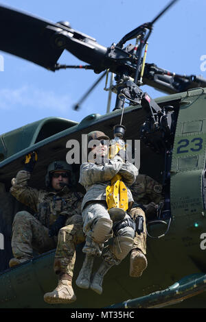 Le sergent de l'US Air Force. Poitra Misty, du 119e Groupe médical, est hissé en haut et en bas de la terre à un 54e Escadron d'Hélicoptères Bell UH-1N d'hélicoptères Iroquois pendant la formation treuil de sauvetage au Camp Gilbert C. Grafton, près de Devils Lake, N.D., le 20 juillet 2017. L'hélicoptère est piloté par le Capitaine Rob Nesko, droite, avec le TEC. Le Sgt. Thomas Liscomb et Trevor Navigant de première classe Beeninga l'exploitation d'un palan. (U.S. Photo de la Garde nationale aérienne capitaine principal Sgt. David H. Lipp/libérés) Banque D'Images