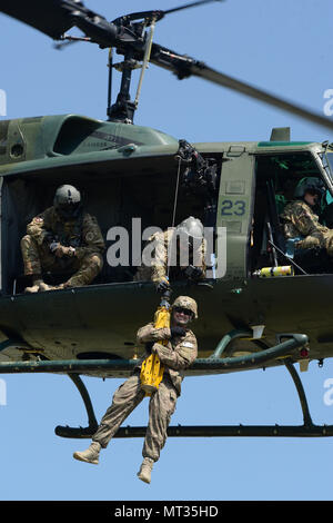 Le sergent-chef de l'US Air Force. Cody Chick, du 219e Escadron des Forces de sécurité, est hissé en haut et en bas de la terre à un 54e Escadron d'Hélicoptères Bell UH-1N d'hélicoptères Iroquois pendant la formation treuil de sauvetage au Camp Gilbert C. Grafton, près de Devils Lake, N.D., le 20 juillet 2017. L'hélicoptère est piloté par le Capitaine Rob Nesko, droite, avec le TEC. Le Sgt. Thomas Liscomb et Trevor Navigant de première classe Beeninga l'exploitation d'un palan. (U.S. Photo de la Garde nationale aérienne capitaine principal Sgt. David H. Lipp/libérés) Banque D'Images