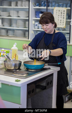 Sachiko Tamura est chef cuisinier à l’Association de promotion de la nourriture de la ville d’Iwakuni qui a servi comme instructeur de cuisine pendant huit ans. Elle a dirigé un cours de cuisine japonais pour les participants de la Marine corps Air Station Iwakuni à Santopia à Otake, au Japon, le 25 juillet 2017, dans le cadre d'un programme d'adaptation culturelle. L'image d'archive documente les instructions de préparation des œufs pour les sushis. Banque D'Images