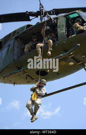 Le capitaine de l'US Air Force au Tchad, de la 119e Brooks Medical Group, est hissé en haut et en bas de la terre à un 54e Escadron d'Hélicoptères Bell UH-1N d'hélicoptères Iroquois, du Minot Air Force Base, au cours de la formation treuil de sauvetage au Camp Gilbert C. Grafton, près de Devils Lake, N.D., le 20 juillet 2017. L'hélicoptère est piloté par le Capitaine Rob Nesko, et le capitaine Joshua Hartmann, AVEC LE TEC. Le Sgt. Thomas Liscomb et Trevor Navigant de première classe Beeninga l'exploitation d'un palan. (U.S. Photo de la Garde nationale aérienne capitaine principal Sgt. David H. Lipp/libérés) Banque D'Images