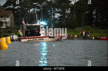 Une Garde côtière 24 pieds d'eau à des fins spéciales Craft-Shallow d'équipage de bateau Station de Chincoteague, en Virginie, les patrouilles le bord d'une zone de sécurité avant la 92e assemblée annuelle Poney Chincoteague nager dans Assateague Channel, le 26 juillet 2017. Le personnel de la station de Chincoteague ont aidé à enlever le canal de kayakistes, plaisanciers et les échassiers d'assurer la sécurité des spectateurs restés pendant l'événement. (U.S. Photo de la Garde côtière canadienne par le maître de 3e classe/Zilnicki Corinne libéré) Banque D'Images