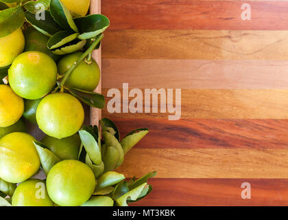 Key Lime lime mexicaine ou dans une boîte en bois sur le plancher, l'un des ingrédient principal nourriture thaïe traditionnelle et horizontale. Banque D'Images