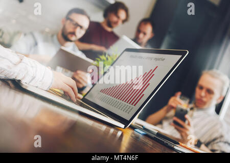 Jeune femme analyste financier examine le rapport annuel de l'entreprise. Graphique ou diagramme sur l'écran de l'ordinateur portable. Le travail d'équipe de gestionnaires sur un nouveau projet Banque D'Images