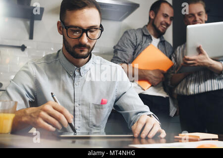 Homme barbu discute de développement de démarrage. Processus de réflexion au bureau. L'équipe de jeunes managers faire la conversation Banque D'Images