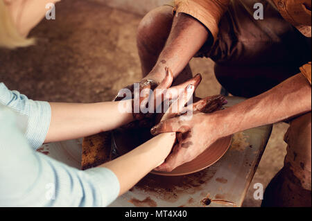 Mains de deux personnes créent sur pot de potier. L'enseignement de la poterie, carftman directeurs les mains Banque D'Images