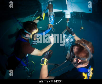 La baie de Souda, la Grèce (3 juillet 2017) Plongeur de la Marine américaine Bujacich Ryan 3e classe, à gauche, et la marine Diver 3 classe Nick Frantz, toutes deux affectées à la région du centre du littoral de l'entretien régional Centre (MARMC), effectuer une plongée sur l'élevage des navires de la classe Ticonderoga-croiseur lance-missiles USS Ville de Huê (CG-66) dans la baie de Souda, la Grèce le 3 juillet 2017. MARMC fournit l'ingénierie et services techniques à l'appui de l'état de préparation de la flotte pour tous les navires, sous-marins et porte-avions. (U.S. Photo par marine Spécialiste de la communication de masse 2e classe Sean Furey) Banque D'Images