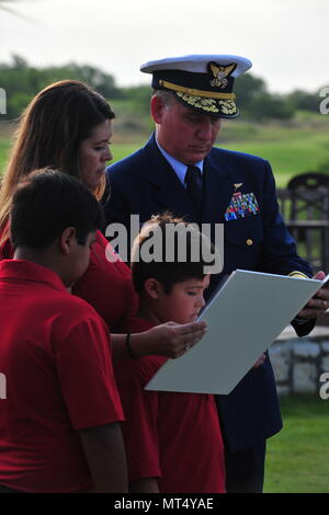 Adm arrière. Dave Callahan, 8e commandant du district de la Garde côtière canadienne, et la famille de Corps des Marines à la retraite Master Sgt. Rodney Buentello lire la citation pour Buentello's Médaille de sauvetage d'or à titre posthume, le 31 juillet 2017, à San Antonio. Lisa Buentello et ses deux fils ont accepté le prix au nom de Rodney Buentello, qui a sacrifié sa vie en sauvant de la noyade deux adolescents de la rivière Medina. U.S. Coast Guard photo de Maître de 2e classe Grant DeVuyst. Banque D'Images