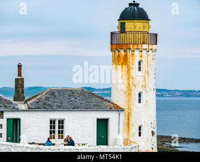 Les personnes à table de pique-nique avec des tasses, faible lumière l'observatoire d'oiseaux de phare, l'île de mai, Firth of Forth, Ecosse, Royaume-Uni Banque D'Images