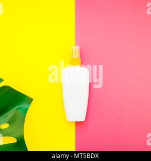 Jungle tropicale Feuilles monstera palmier bouteille vide de l'écran solaire et immersive sur carré lumineux jaune et rose papier duotone arrière-plan. Vacances d'été cre Banque D'Images