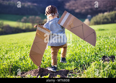 Heureux bébé garçon avec des ailes à l'extérieur au printemps la nature. Banque D'Images