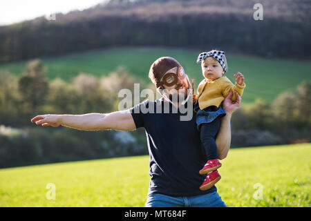 Un père avec son enfant fille à l'extérieur au printemps la nature. Banque D'Images