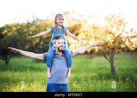 Petite fille un père donnant piggyback ride au printemps la nature. Banque D'Images