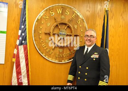 PORT HUENEME, Californie, le Naval Surface Warfare Center, Port Hueneme ingénieur Chef de Division Le Capitaine Michael Ladner se tient fièrement à côté de la plaque en forme de roue, qui porte le nom de tous les ingénieurs en chef de la division centre de guerre qui ont servi avant lui, le 20 juillet. (170720-N-ZC671-001) U.S. Navy photo de Brian/Melanephy publié Banque D'Images