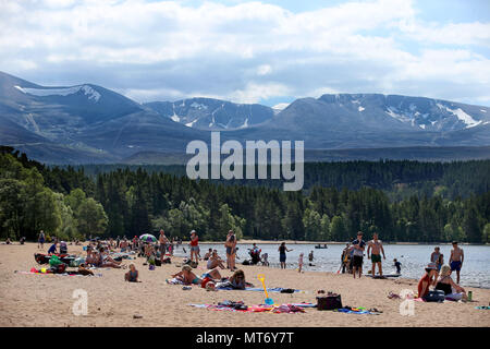 Les dernières plaques de neige restent sur les Cairngorms car les gens profiter du beau temps sur la plage la plus élevée au Royaume-Uni à Loch Morlich près d'Aviemore, comme les Britanniques pourraient voir la journée la plus chaude de l'année ce lundi férié. Banque D'Images