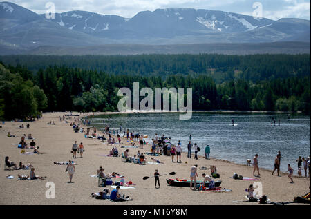 Les dernières plaques de neige restent sur les Cairngorms car les gens profiter du beau temps sur la plage la plus élevée au Royaume-Uni à Loch Morlich près d'Aviemore, comme les Britanniques pourraient voir la journée la plus chaude de l'année ce lundi férié. Banque D'Images