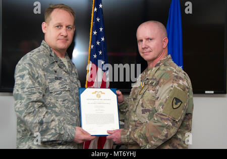 Le Major de l'armée américaine Sean Anderson, droite, et le Colonel Daniel Knight, 673d, commandant du Groupe de soutien de mission pose devant l'appareil photo lors d'un Air Force Commendation Medal decoration présentation à Joint Base Elmendorf-Richardson, Alaska, le 31 mars 2017. Bien qu'affecté à la 673e Escadron en tant que partie d'un agent de gestion des marchés, Anderson a entrepris une expansion de l'installation du système de notification de masse plus de 295 000 $. Anderson est affecté à la 673d inconvénients. (U.S. Photo de l'Armée de l'air par le sergent. Sheila deVera) Banque D'Images