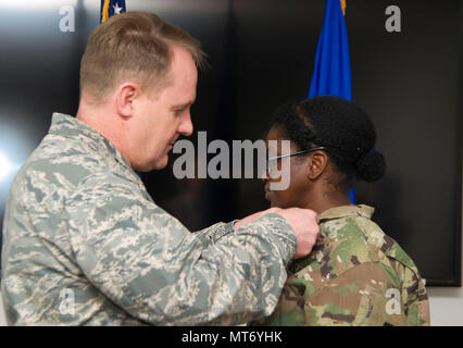 U.S. Air Force Colonel Daniel Knight, 673d, commandant du Groupe de soutien à la Mission de l'Armée de l'air les broches médaille armée de Sgt. 1st. Ashly classe McBunch au cours d'une cérémonie à Joint Base Elmendorf-Richardson, Alaska, le 31 mars 2017. (U.S. Photo de l'Armée de l'air par le sergent. Sheila deVera) Banque D'Images