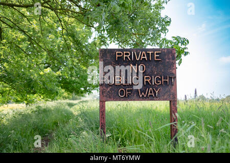 Grand terrain privé signer vu au bord d'un grand champ arable en été. Un sentier public fonctionne à côté de ce signe. Banque D'Images