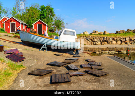 Old wooden fishing boat standing on the beach for repairing works