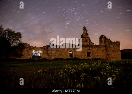 Exposition longue photographie de les ruines d'un château avec un horizon plein de traces d'étoiles. Banque D'Images