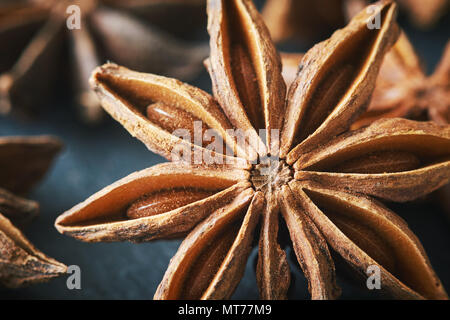 L'anis étoilé (Illicium verum) noir sur fond rustique Banque D'Images