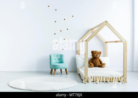 Chambre Simple avec intérieur pour enfants bricolage lit avec un ours en peluche, fauteuil, tapis ronds et étoiles sur le mur. Place pour votre produit Banque D'Images
