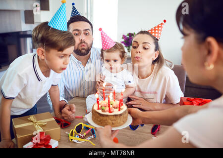 Une famille heureuse avec une bougie gâteau célèbre un anniversaire Banque D'Images